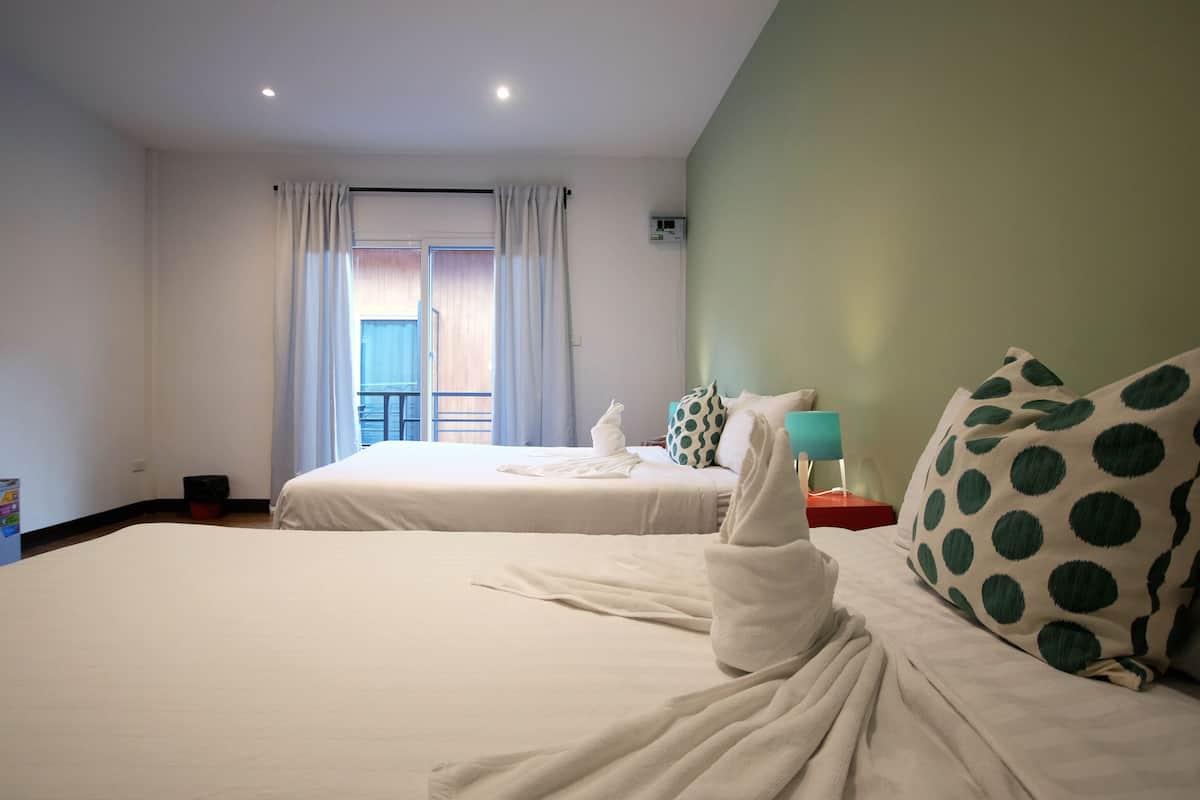 A hotel room with two beds, a balcony, and a minibar.