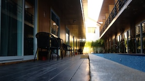 Un couloir doté d’un plancher en bois, de portes en verre et offrant une vue sur le coucher de soleil.