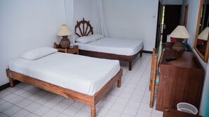 Una habitación con dos camas de madera, un aparador de madera y un espejo.