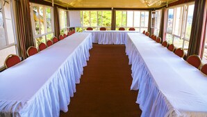 A conference room with a long table and chairs, large windows, and a white ceiling. - Step Town Hotel (Kigali)