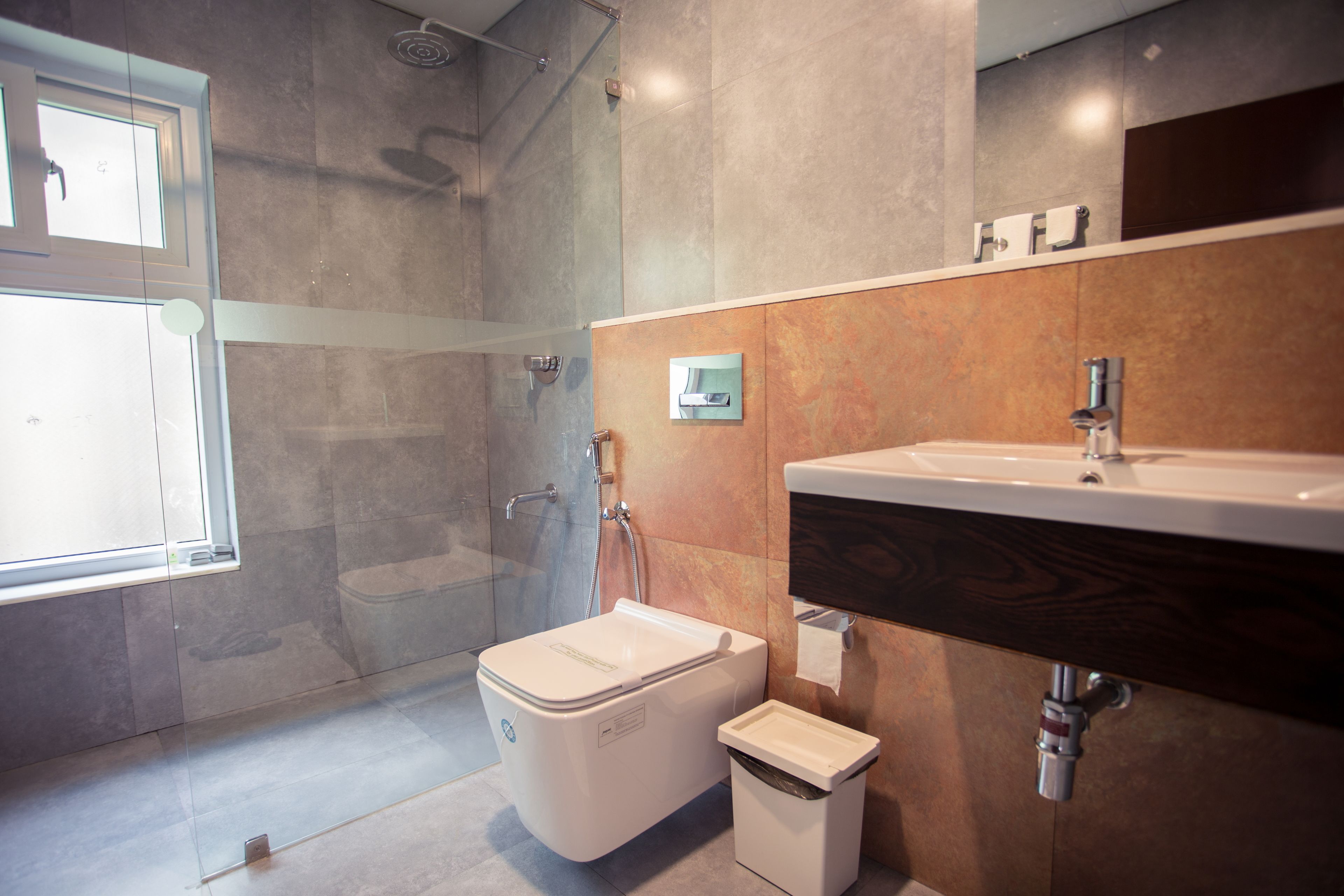 A modern bathroom with a toilet, bidet, and sink.