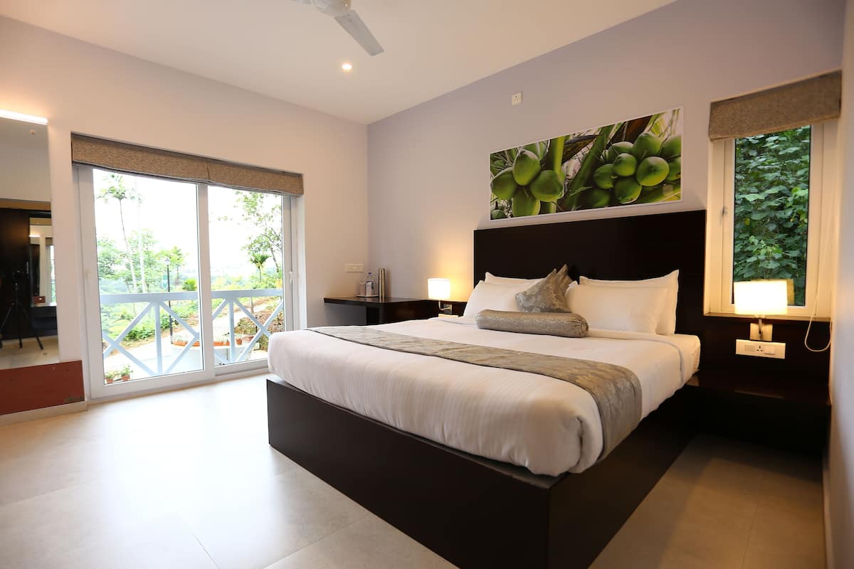 Un dormitorio moderno con una cama grande, un balcón y vistas a zonas verdes.