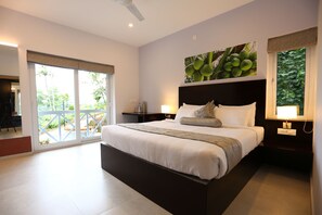 Un dormitorio moderno con una cama grande, un balcón y vistas a zonas verdes.