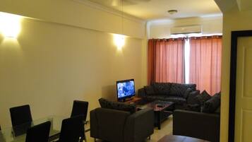 Deluxe Apartment, 3 Bedrooms | Living room | Flat-screen TV