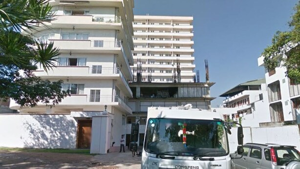 A multi-story building with balconies, a parked van, and a clear sky. - BRAMA Servizez - Capital Park (Colombo)