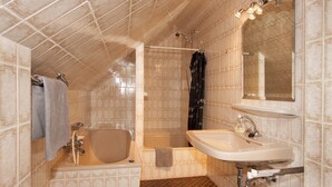 Une salle de bain avec une baignoire, une douche et un lavabo.