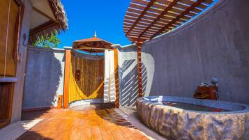 Relax in a serene outdoor space with an entrance, hot tub, and seating area.