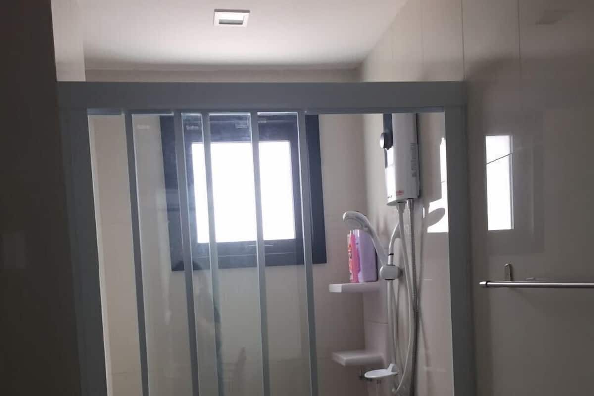 A modern bathroom with a glass door, a shower area, and a toilet.