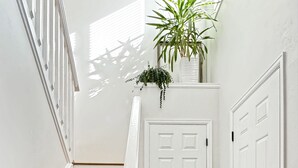 A staircase with wooden steps and white railings, leading to a white door with a black handle. - Walnut Mews - Quiet Creekside townhome next to Pearl Street (Boulder)