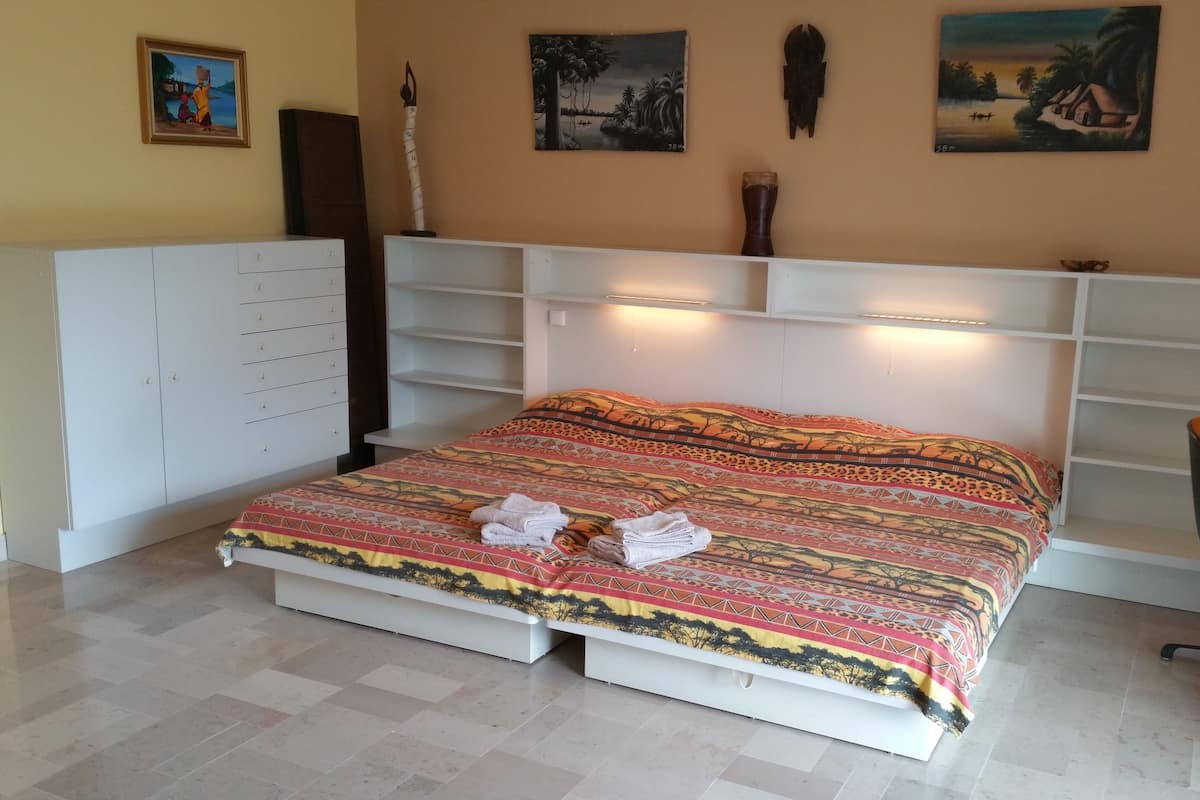 A bedroom with a bed, a desk, and a chair.