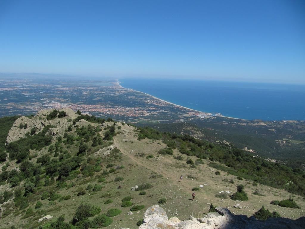 A coastal landscape with a rocky hill and a view of the coastline.