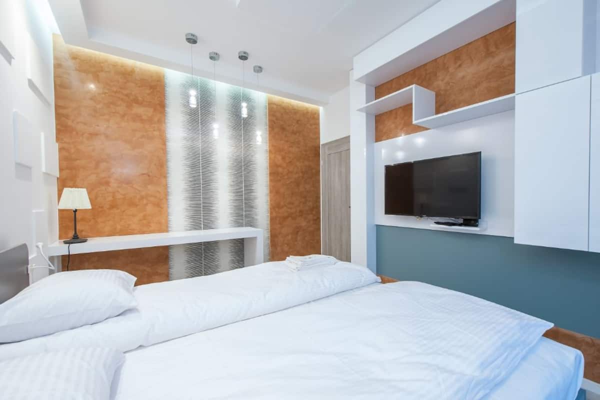 Une chambre d’hôtel moderne dotée d’un grand lit, d’un téléviseur intégré et d’un décor mural original.