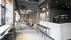 A modern interior with a bar area, seating, and a kitchen. - Four Points Flex by Sheraton Aalborg (Aalborg)