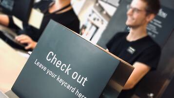 Ein Empfangsschalter mit einem Schild, auf dem 'Check out' und 'Schlüsselkarte hier abgeben' steht.