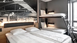 A modern hotel room with a bunk bed, a wooden headboard, a desk with a chair, and a large window offering a view of the interior space. - Four Points Flex by Sheraton Aalborg (Aalborg)