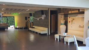 A spacious lobby with a sofa, chairs, and a table. - Domaine des Pierres Dorées (Ternand)
