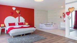 A modern bedroom with a red accent wall, a white bed, and a vanity with a mirror. - Domaine des Pierres Dorées (Ternand)