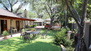 A patio with outdoor furniture, a covered seating area, and a view of a residential street. - Four Seasons Guesthouses (Lephalale)
