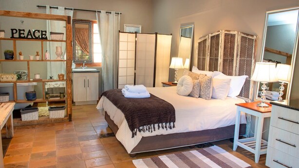 A bedroom with a bed, bedside table, dresser, and a wardrobe. - Four Seasons Guesthouses (Lephalale)