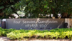 A sign for Four Seasons Guesthouses with a contact number. - Four Seasons Guesthouses (Lephalale)
