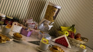 Un bufé de desayuno con diversas opciones de comida, como pasteles, frutas y bebidas.