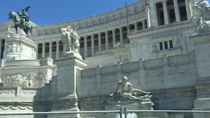 Un edificio grande de arquitectura clásica, con estatuas y columnas.