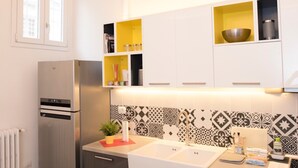 A compact kitchen with a built-in refrigerator, a double sink, and a small countertop area. - Elisa Apartment (Florence)
