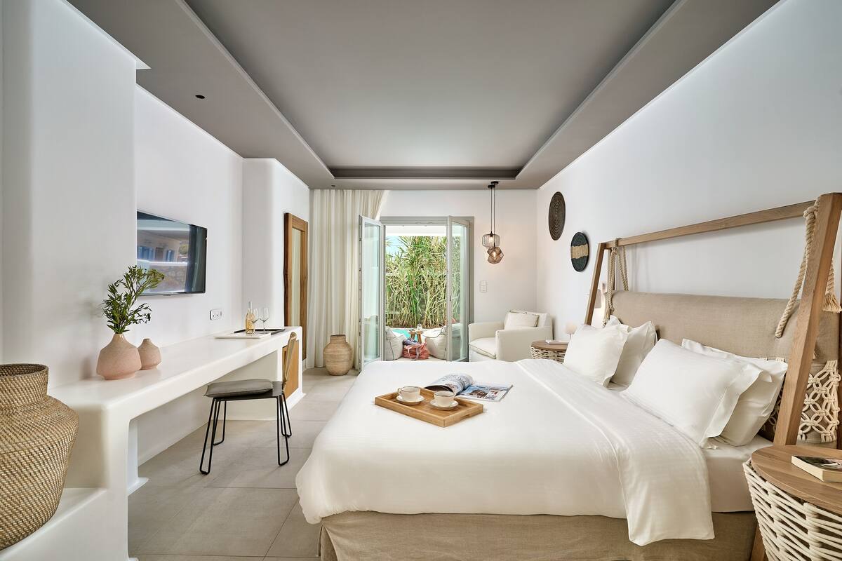 Un dormitorio moderno con cama, mesita de noche y vistas al exterior.
