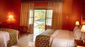 Ein Hotelzimmer mit zwei Betten, einem Balkon und Seeblick.