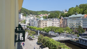 Un paisaje urbano a orillas del río con edificios históricos, un puente y una fuente.
