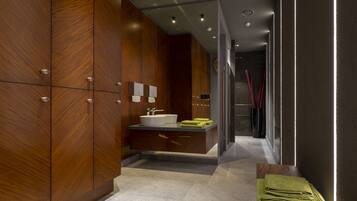 A modern bathroom with wooden cabinets, a sink, and a mirror.