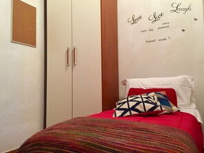 A bedroom with a bed, a wardrobe, and a motivational poster on the wall. - San Lorenzo (Florence)