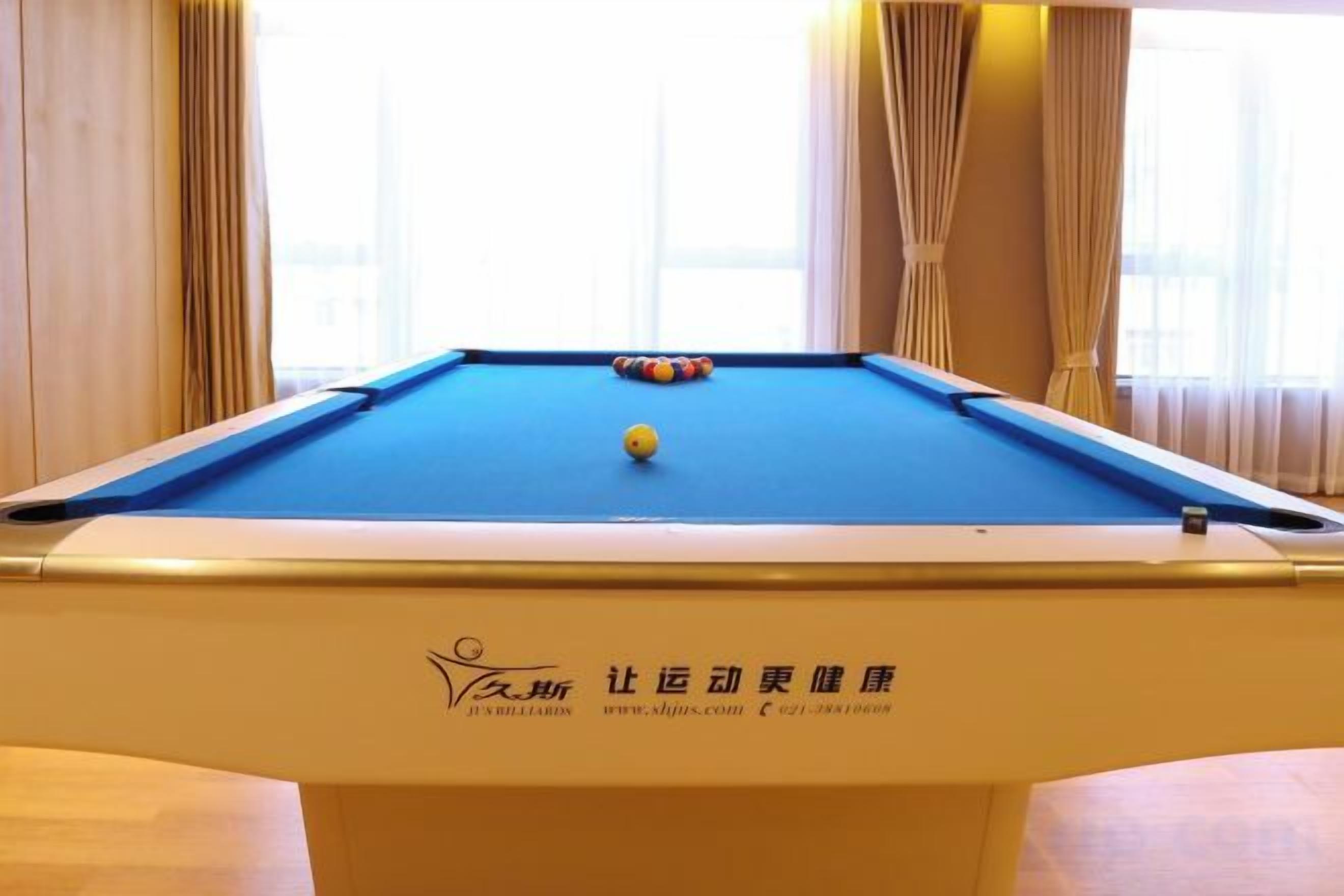 Une table de billard ornée d’un logo et d’une inscription indiquant qu’il s’agit d’un club de remise en forme.