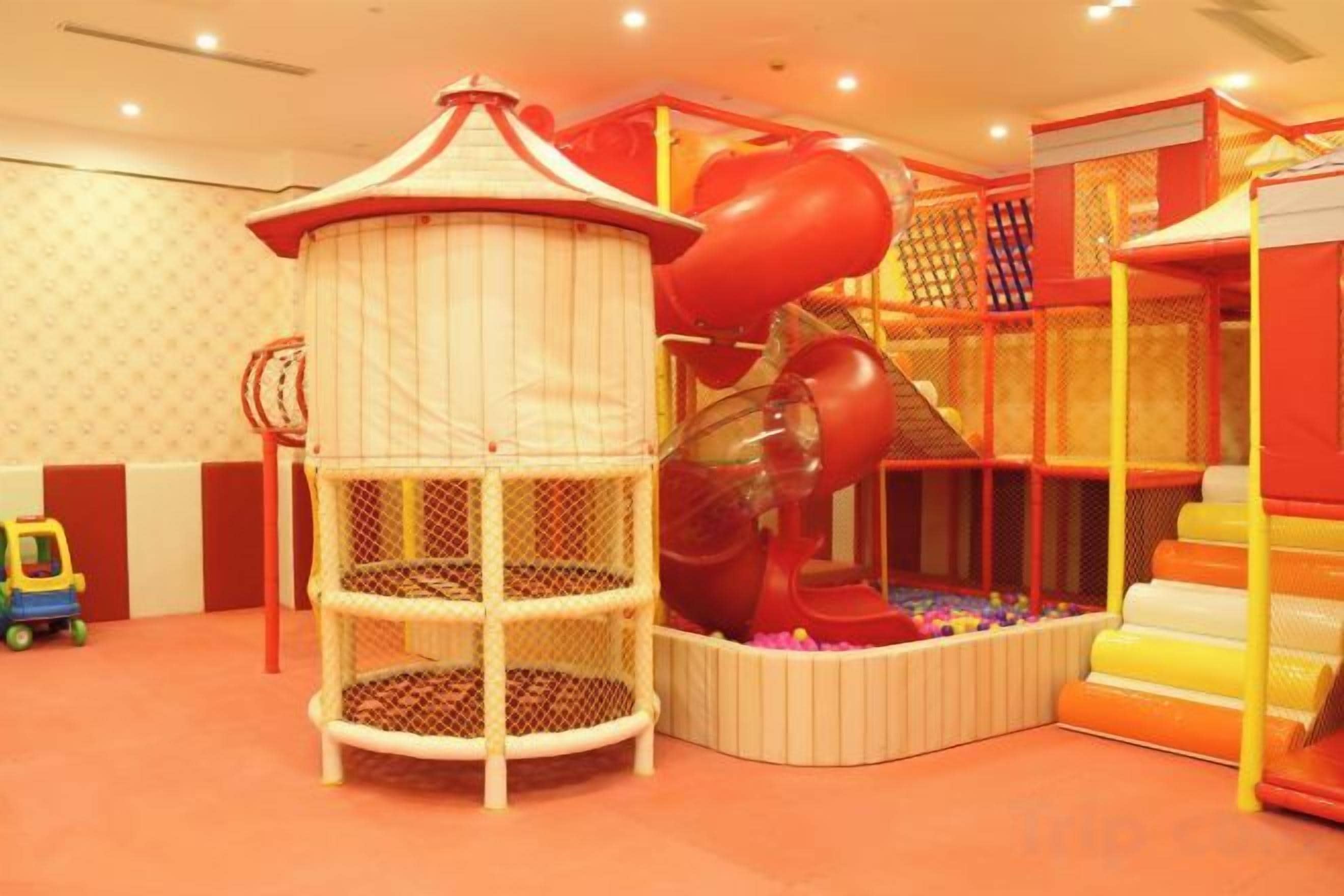 A children's play area with a slide, climbing structures, and a playhouse.