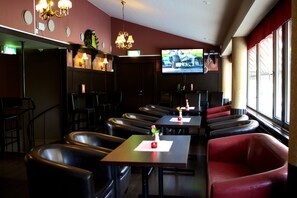 A restaurant with booths and tables, a TV screen, and a chandelier. - Stopet Hotell & Värdshus (Grangesberg)