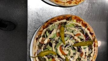 Zwei Pizzen auf einer Metallplatte.