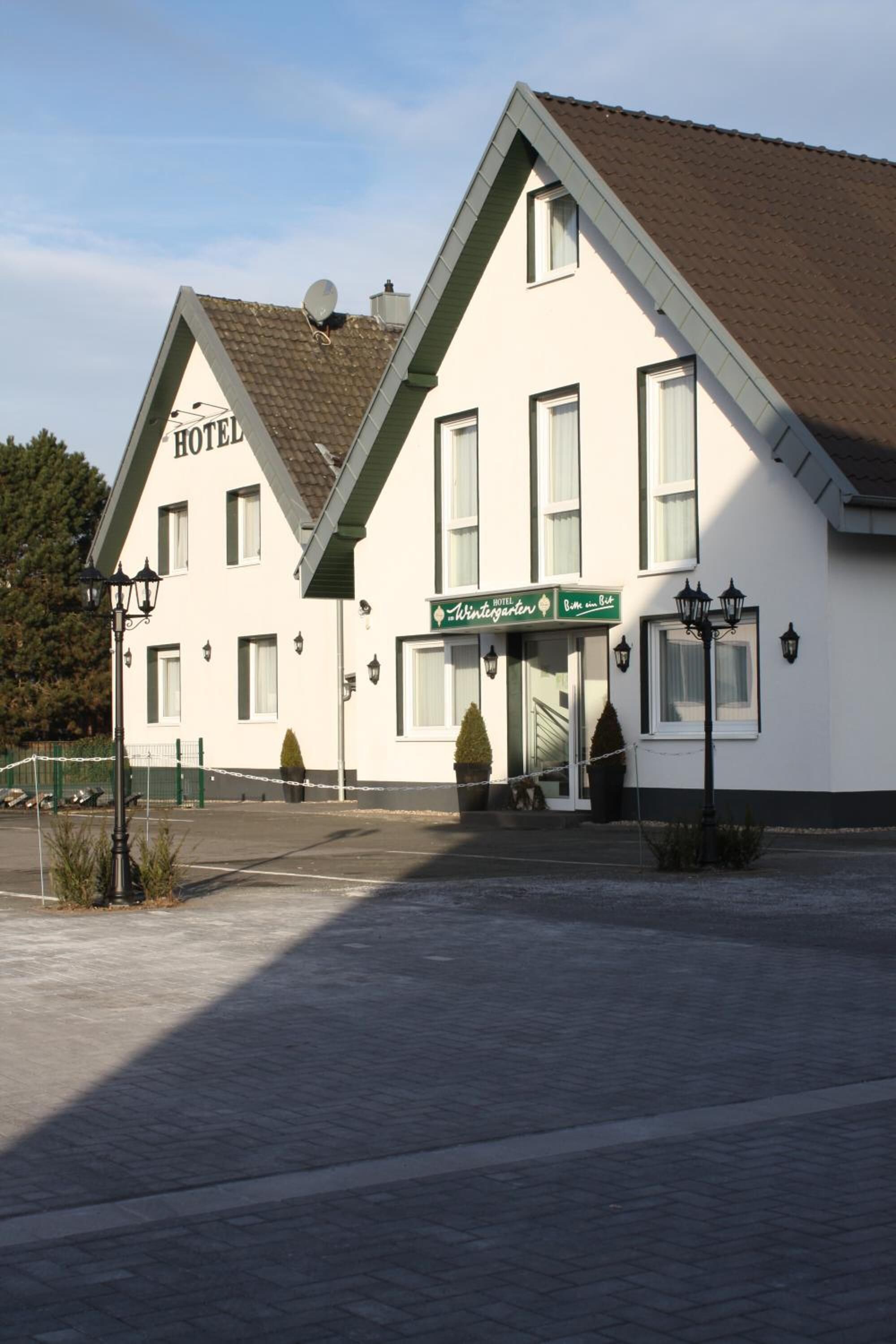 Un hôtel de deux étages avec une enseigne indiquant « Hôtel Wintergarten ».