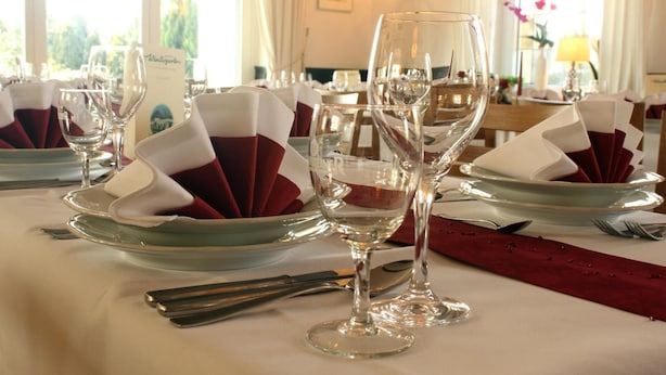 A table set for a formal dining experience with clear glassware and folded napkins. - Hotel am Wintergarten (Bocholt)
