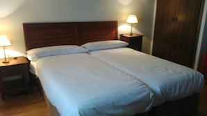 A double bed with white linens, two bedside tables with lamps, and a wooden headboard. - La Picota (Valverde de la Vera)