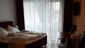 A hotel room with a bed, a desk, and a chair. - Hotel Hafez (Bad Salzuflen)