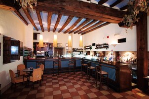 A bar with wooden beams, checkered floor, and bar stools.