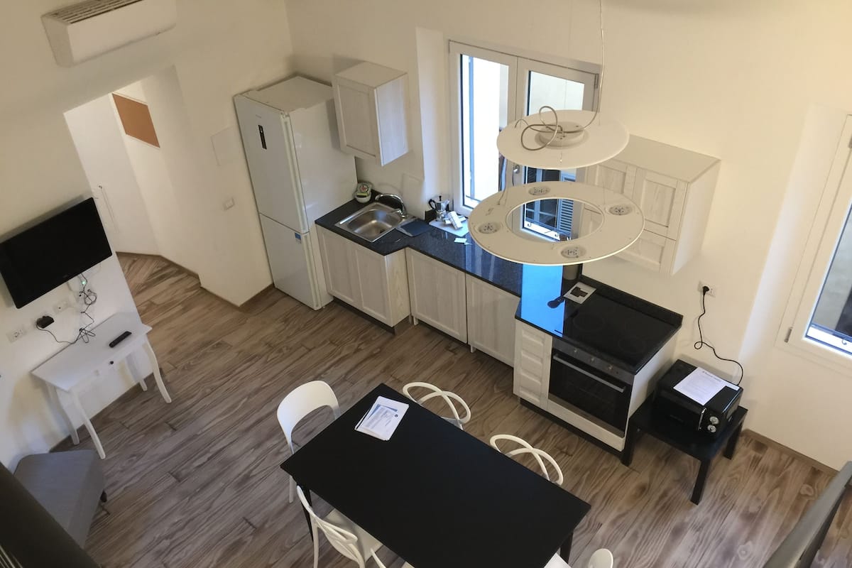 Una cocina compacta con comedor, refrigerador, lavaplatos y estufa.
