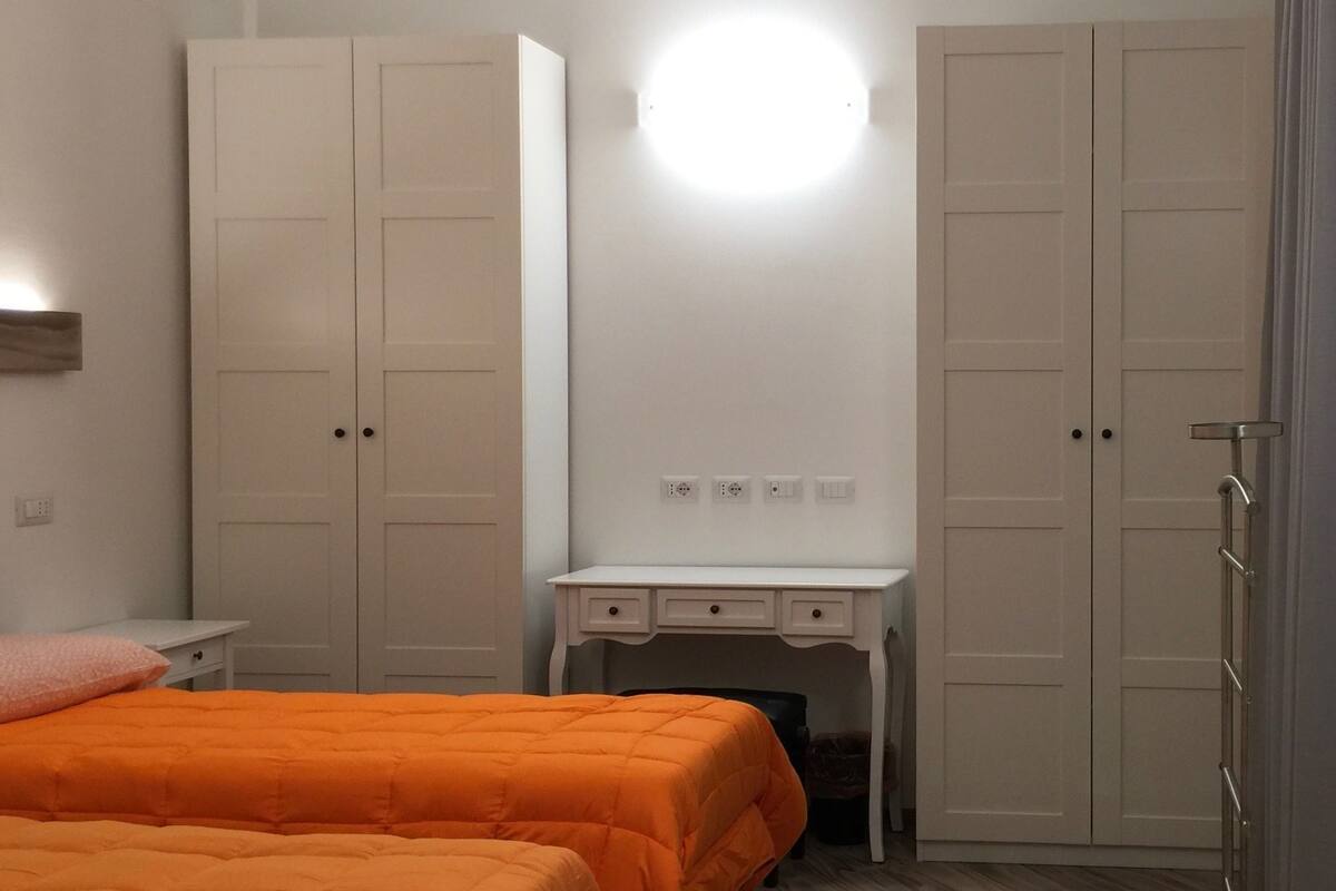 Un dormitorio con una cama, un escritorio y dos armarios.