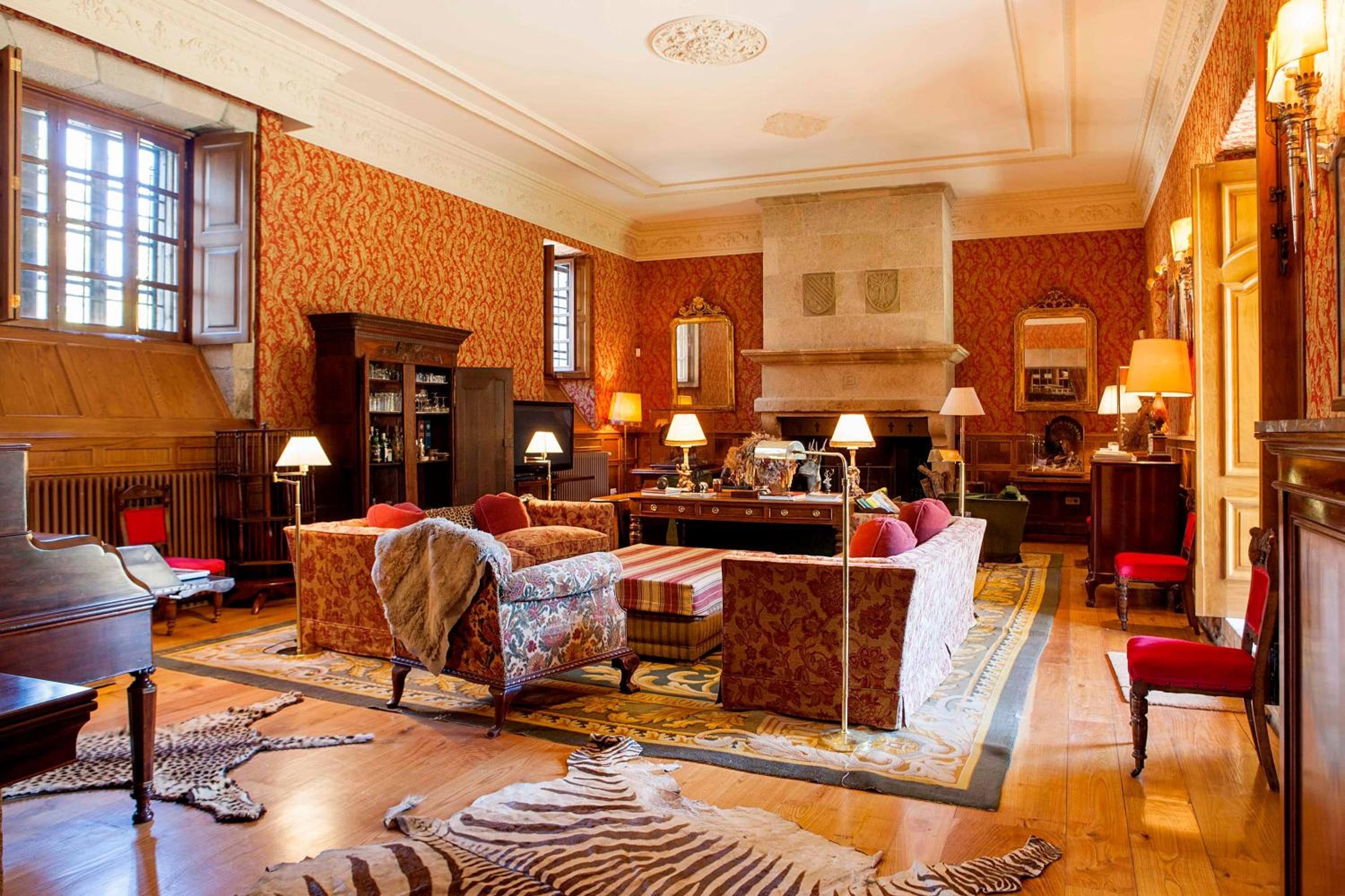 A spacious room with a grand piano, a fireplace, and a large window.