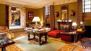 A traditional room with a fireplace, leather sofa, and a table with books. - Pazo De Brandeso & Country Club (Arzua)