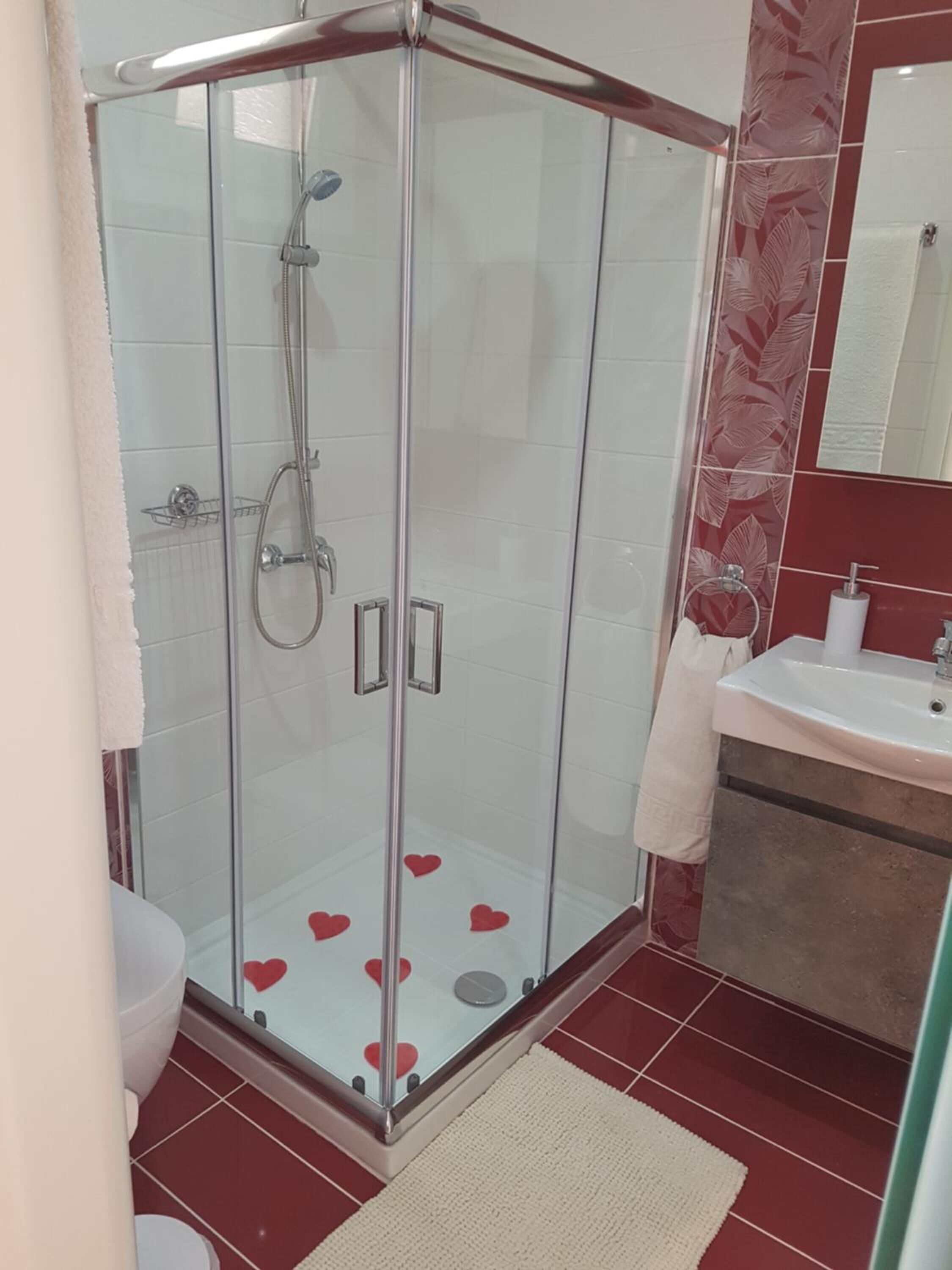 A glass-enclosed shower with a white sink and a mirror above it.