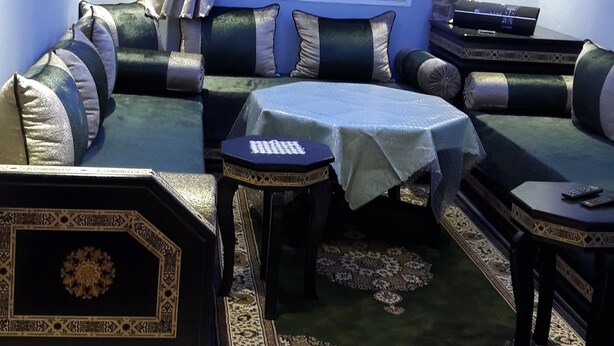 Een moderne woonkamer met een hoekbank, een klein tafeltje en een decoratief vloerkleed.