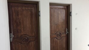Twee houten deuren met ingewikkelde versieringen en moderne deurklinken.