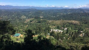 A panoramic view of a mountainous landscape with scattered buildings and greenery. - Yoho The Train View (Nanuoya)