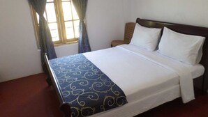 A single bed with a wooden headboard, white bedding, and a blue patterned bedspread. - Yoho The Train View (Nanuoya)